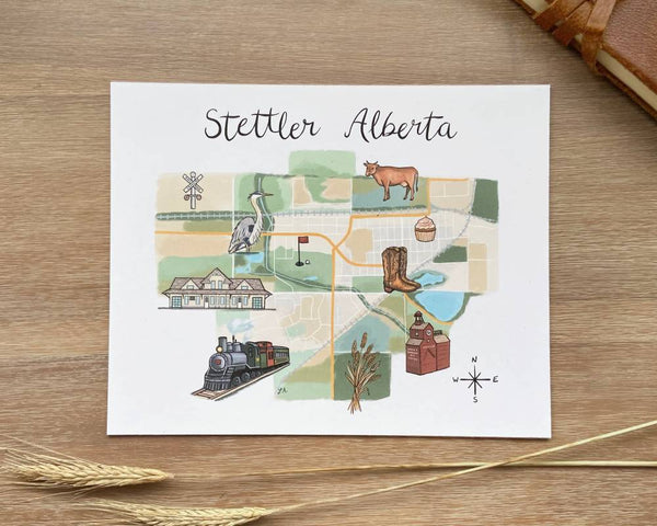 Map of Stettler Alberta on wood background with wheat and leather journal